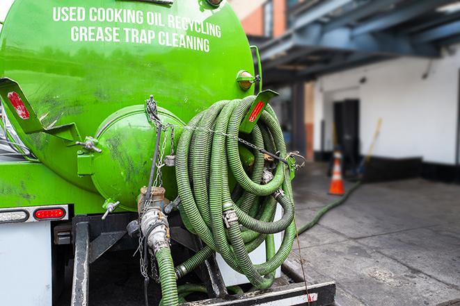 a grease trap being pumped by a sanitation technician in Maywood, CA